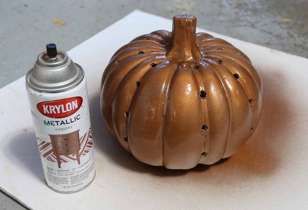 copper spray painted pumpkin with holes