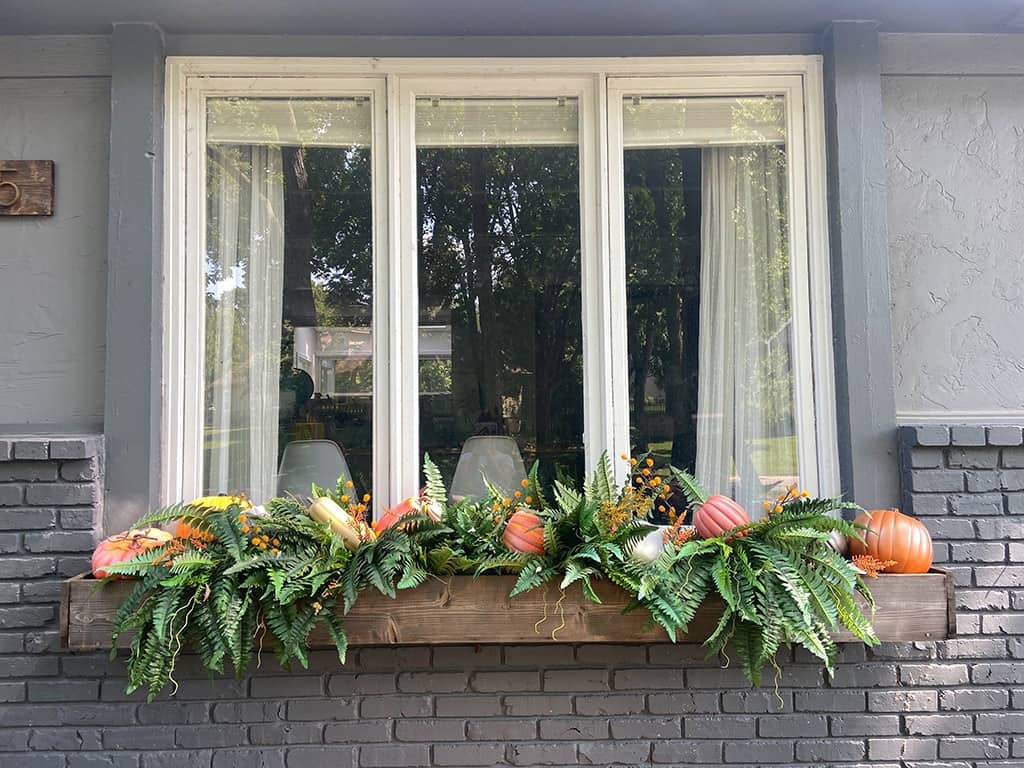 outdoor fall decor and window boxes with pumpkins and faux ferns