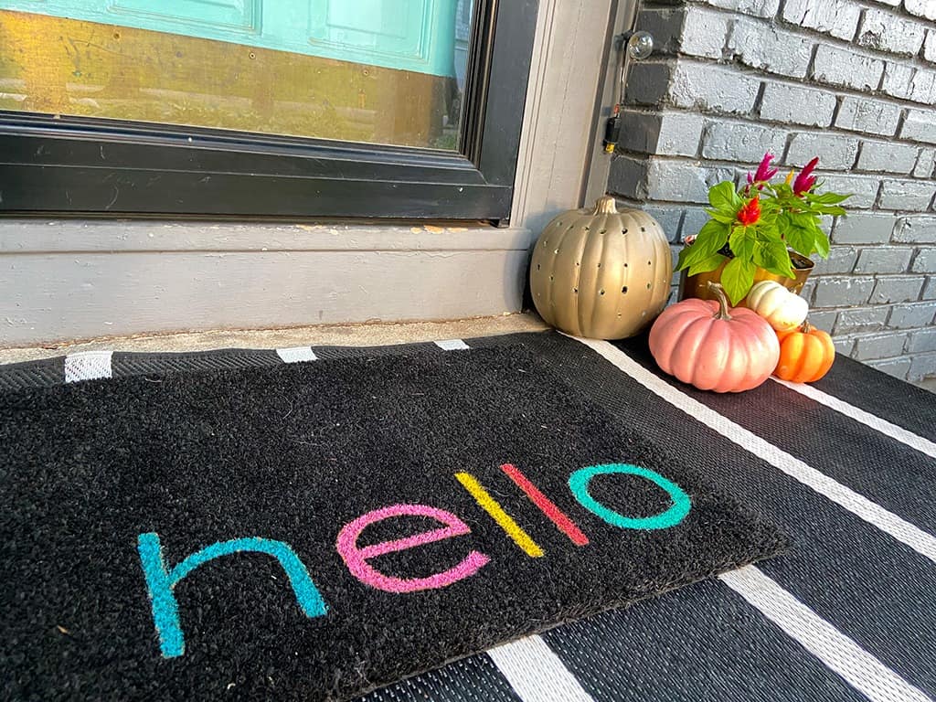 A colorful and modern outdoor fall decor with plants and pumpkins