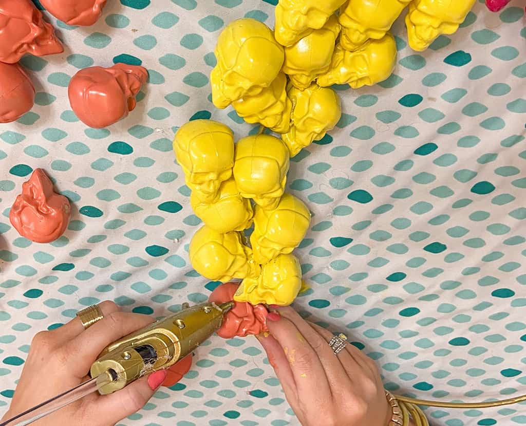 gluing spray painted skulls onto a halloween wreath