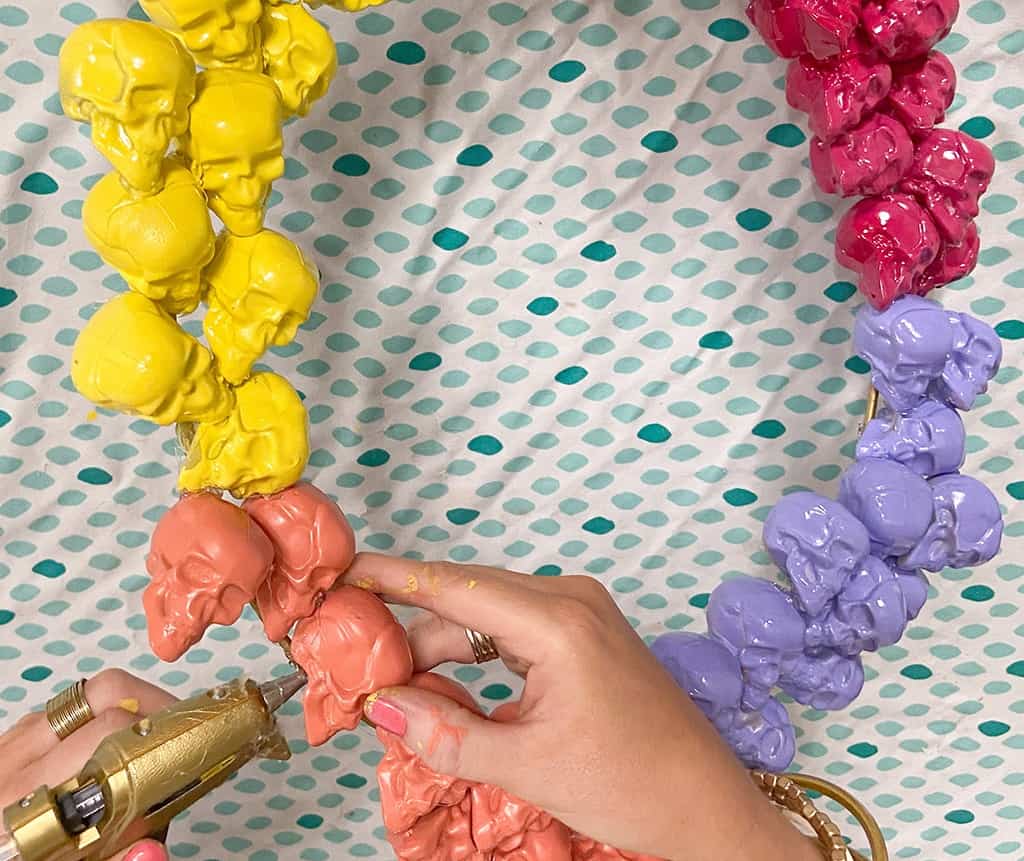 gluing spray painted skulls onto a halloween wreath