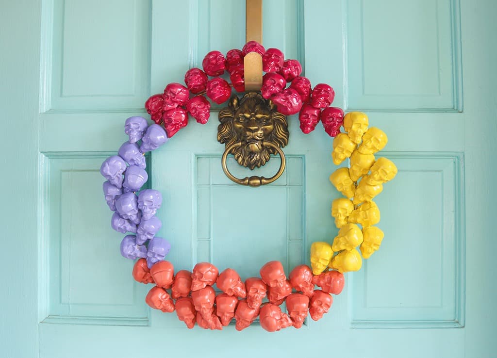 Learn how to make a DIY colorful and modern skull Halloween wreath that will look amazing on your front door this fall. So festive!