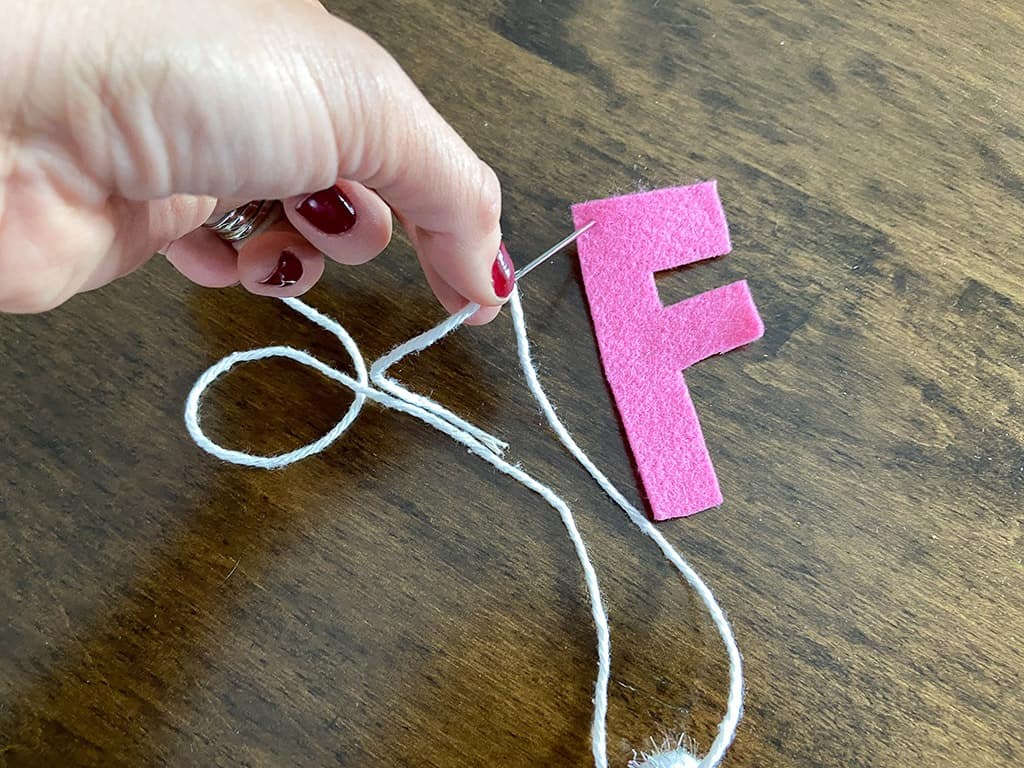 needle and yarn for stringing felt letters on a banner