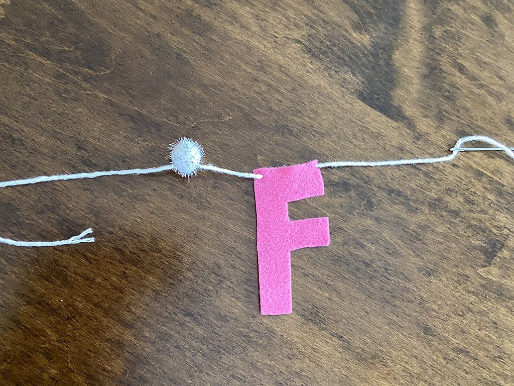 needle and yarn for stringing felt letters on a banner