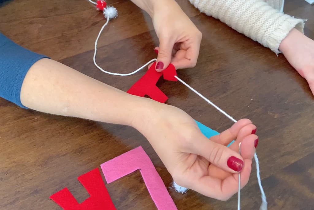 needle and yarn for stringing felt letters on a banner