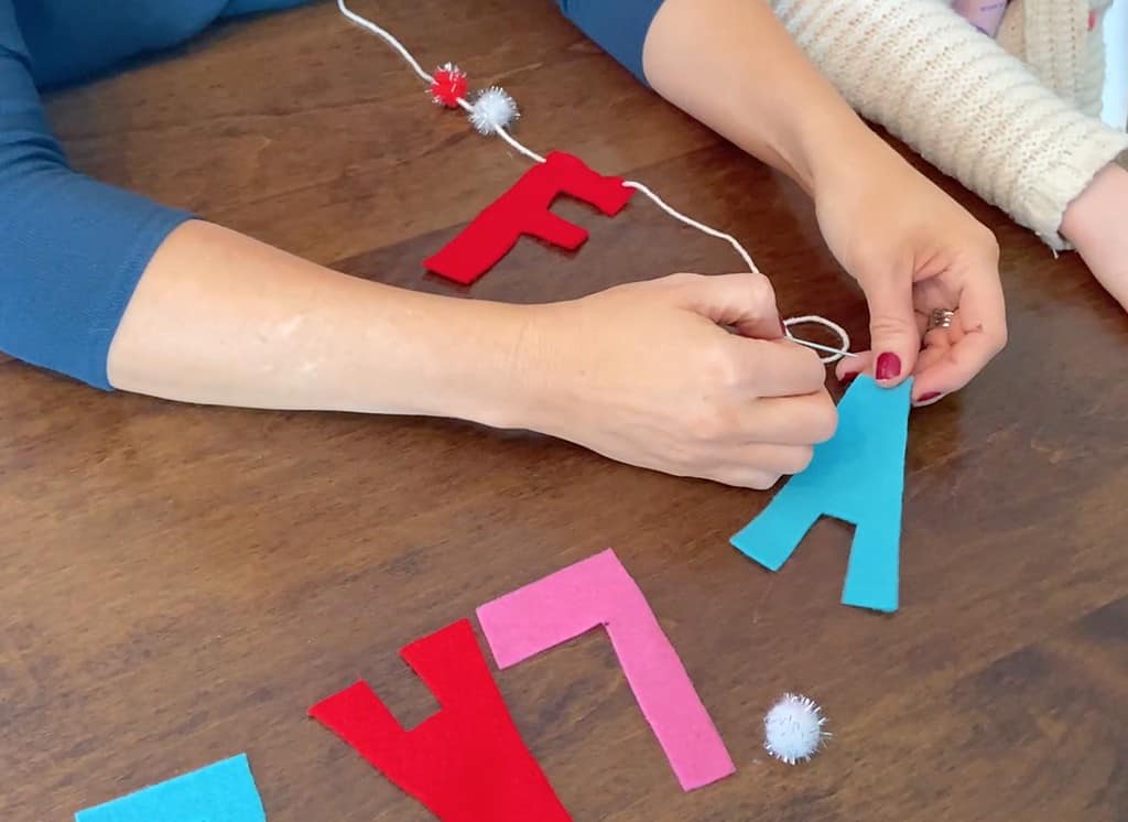 needle and yarn for stringing felt letters on a banner