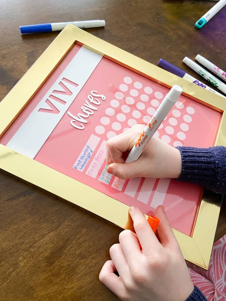 Adding chores to a kids DIY chore chart with dry erase markers 