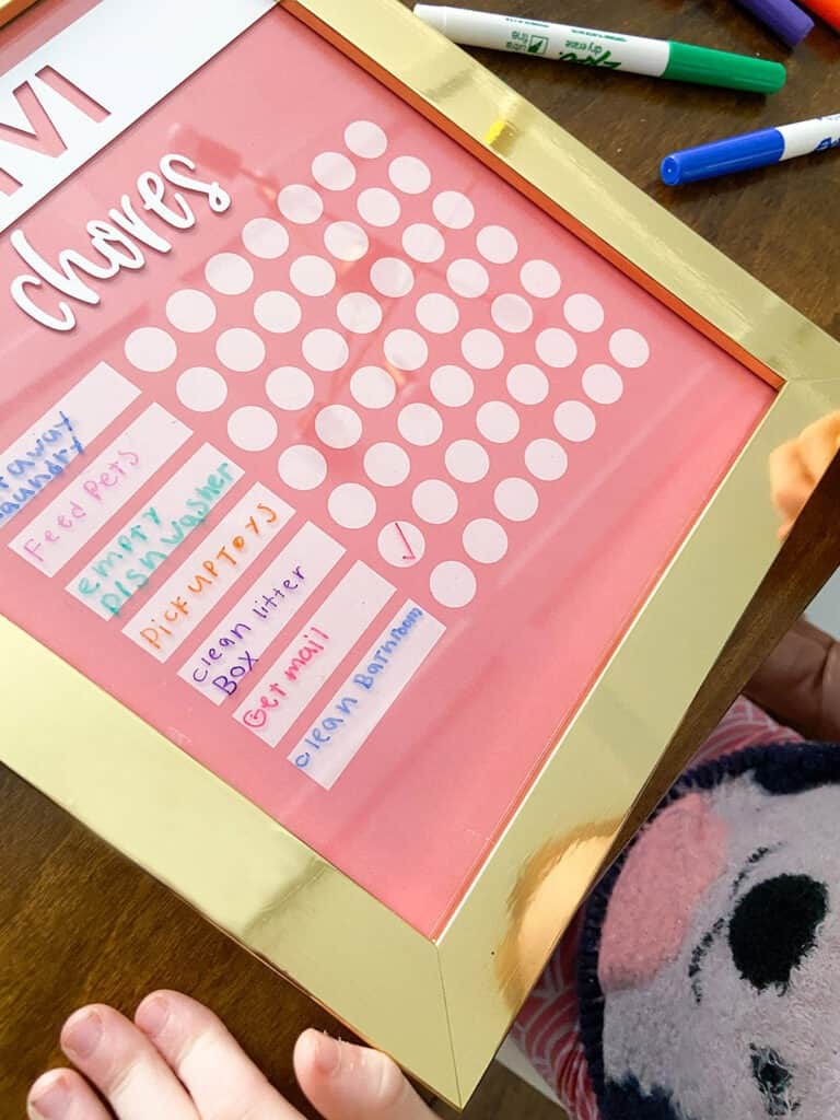 Adding chores to a kids DIY chore chart with dry erase markers 