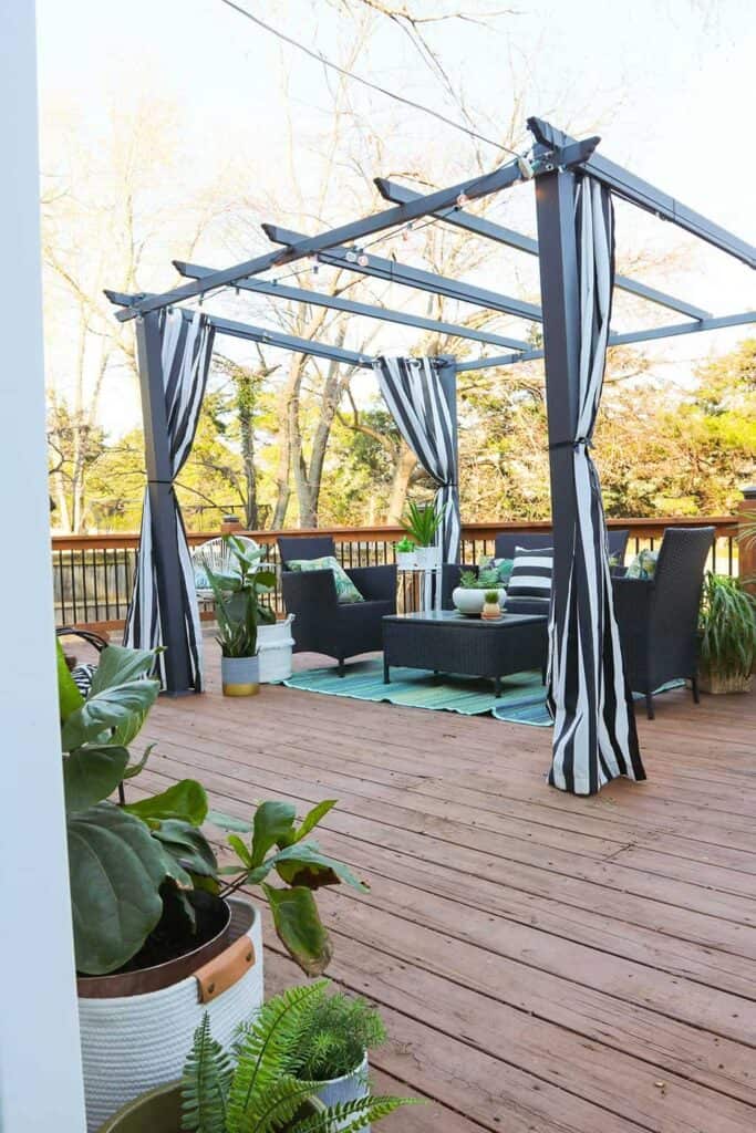 large wood deck with black and white strips and palm leaves