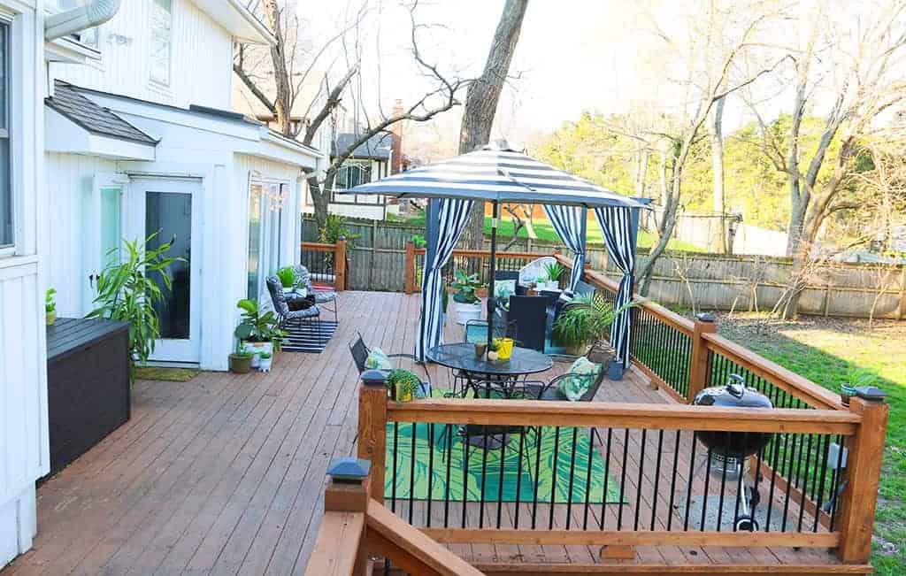 large wood deck with black and white strips and palm leaves