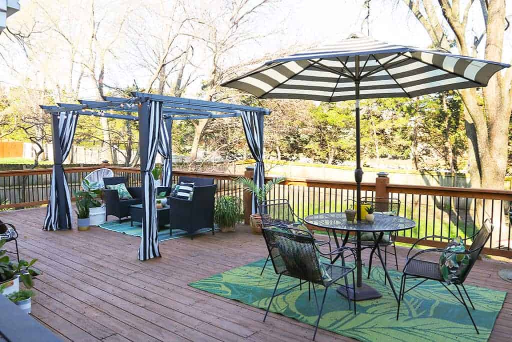 large wood deck with black and white strips and palm leaves