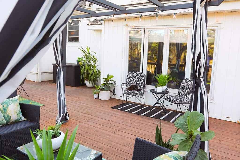 large wood deck with black and white strips and palm leaves