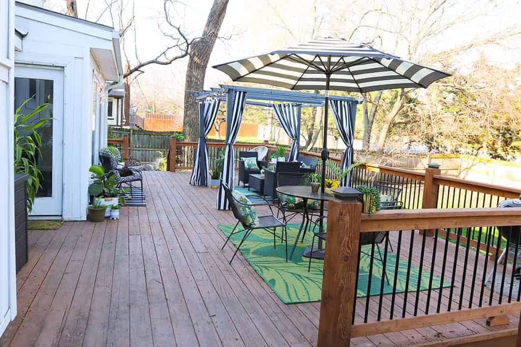 large wood deck with black and white strips and palm leaves