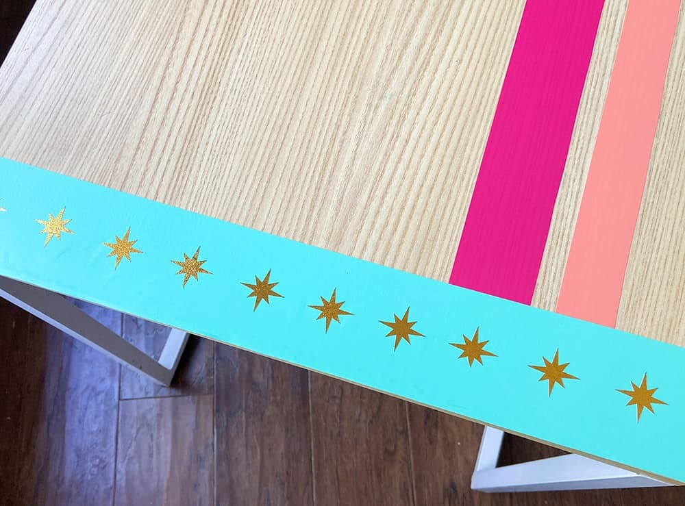 turquoise, hot pink, and coral vinyl design on a desk top with modern gold accents