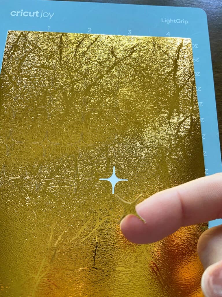 cut gold vinyl with Cricut Joy, hand weeding the shape from the vinyl