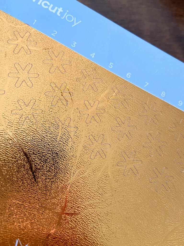 cut gold vinyl with Cricut Joy, hand weeding the shape from the vinyl