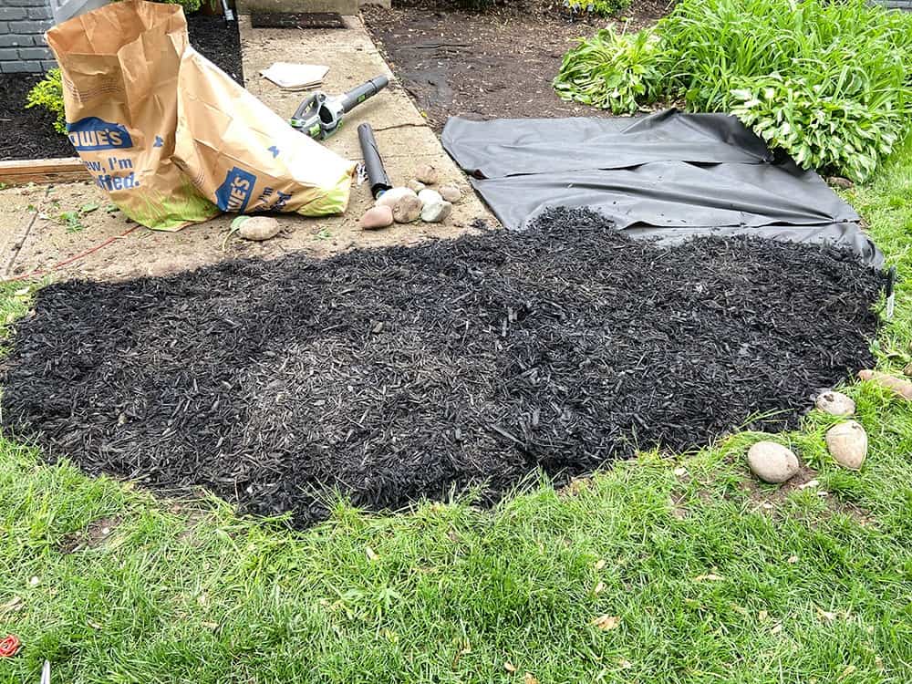 adding weed mat and mulch to landscaping beds