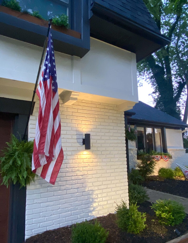 How a DIY wood cladding slat porch wall added some much needed warmth and curb appeal to our home! Get the full tutorial and product links. Exterior modern lights at night.