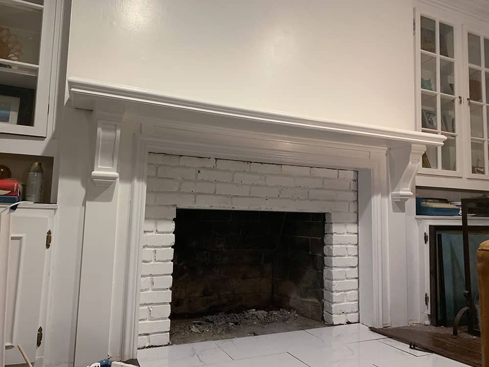 A step-by-step DIY fireplace makeover tutorial – See how it went from extra creepy to clean and classic on a very small budget! 