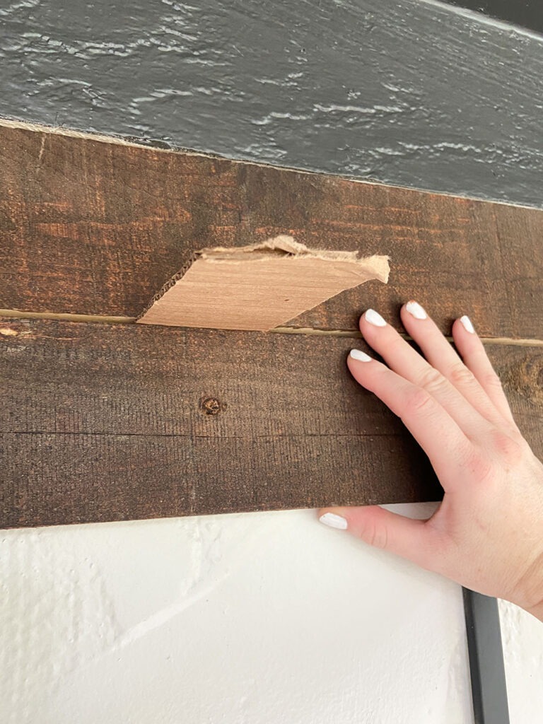 Installing wood slat to wall using a level, shim, and drill