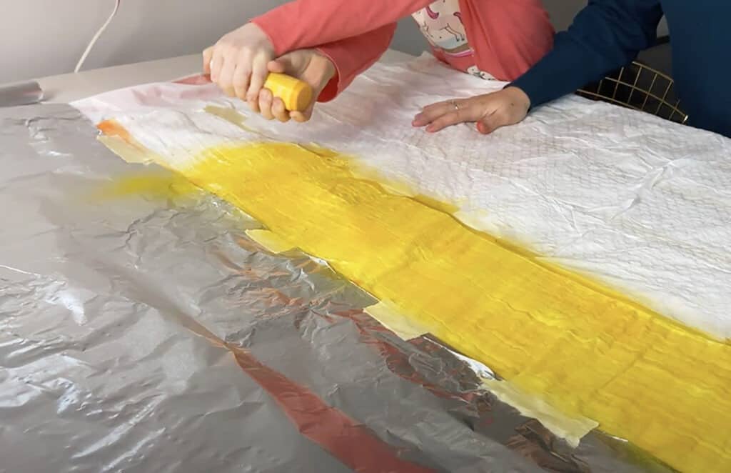 spray yellow tumble dye on muslin blanket