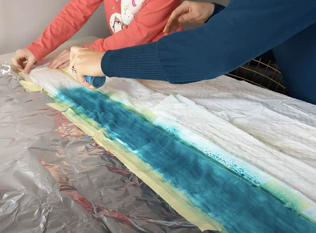 spray turquoise tumble dye on muslin blanket