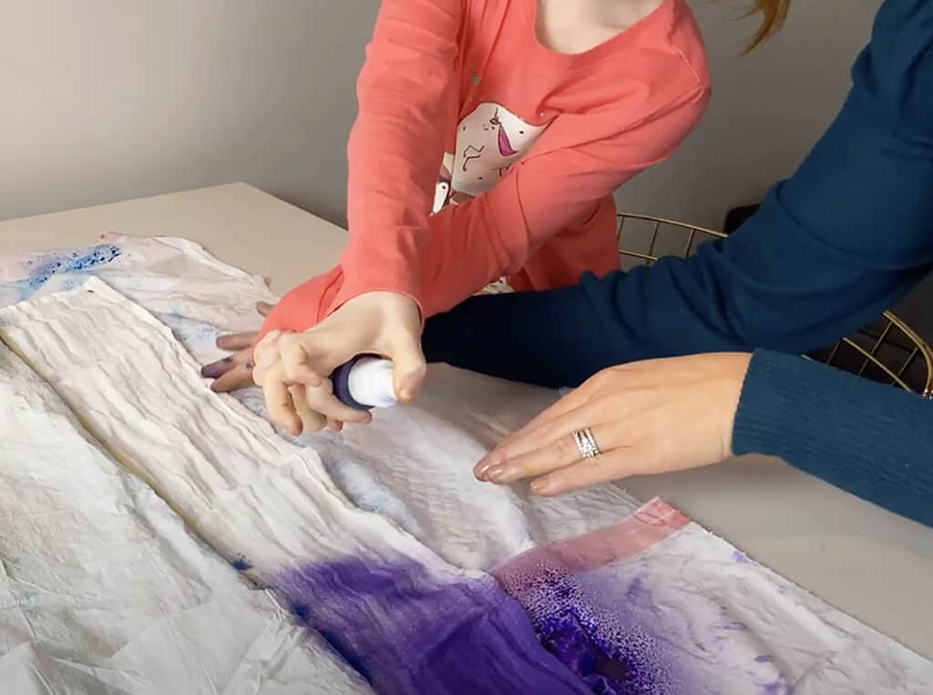 spray purple tumble dye on muslin blanket