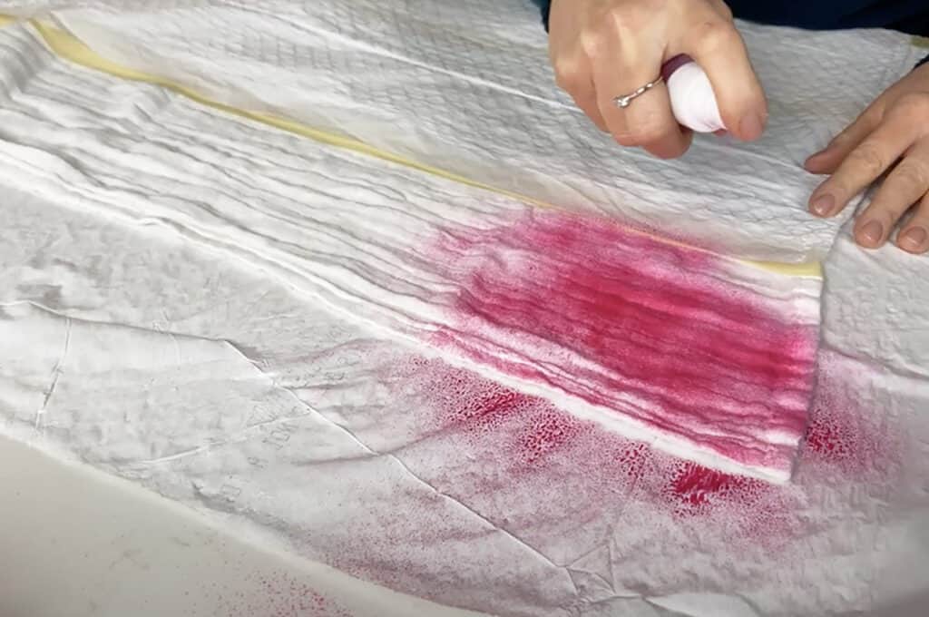 spray hot pink tumble dye on muslin blanket