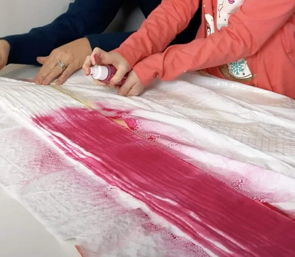 spray hot pink tumble dye on muslin blanket