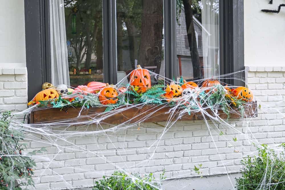 a window box full of light up pumpkins, skulls, and spiderwebs