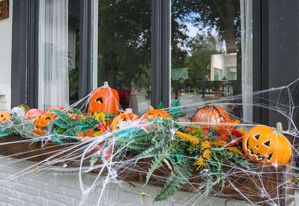 a window box full of light up pumpkins, skulls, and spiderwebs