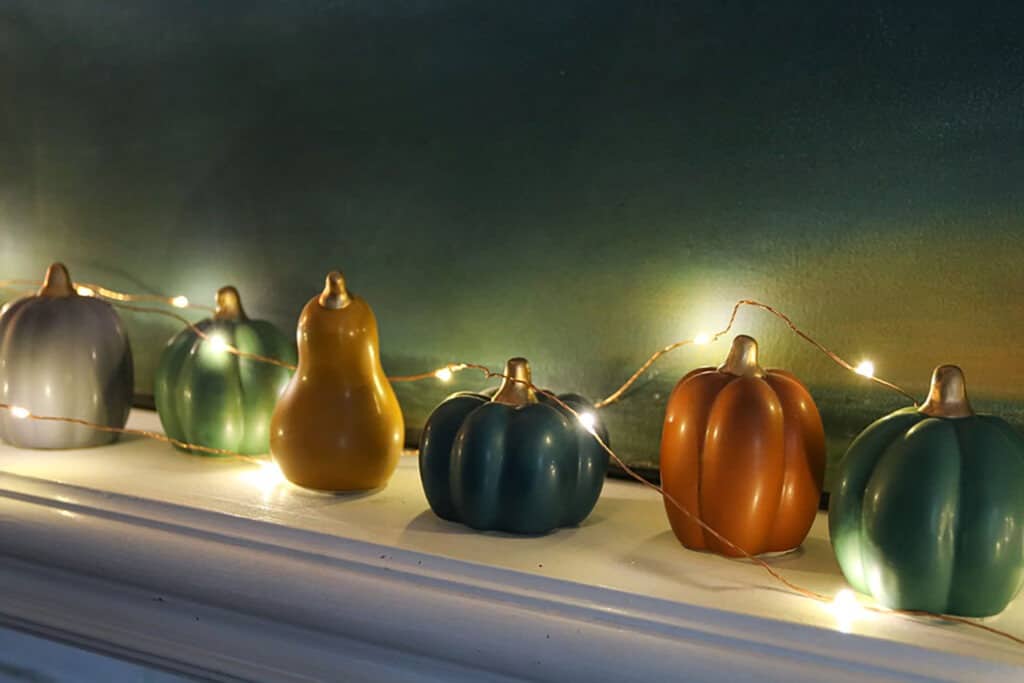 Fall decorating tips for your fireplace mantel using colorful faux pumpkins and fairy lights