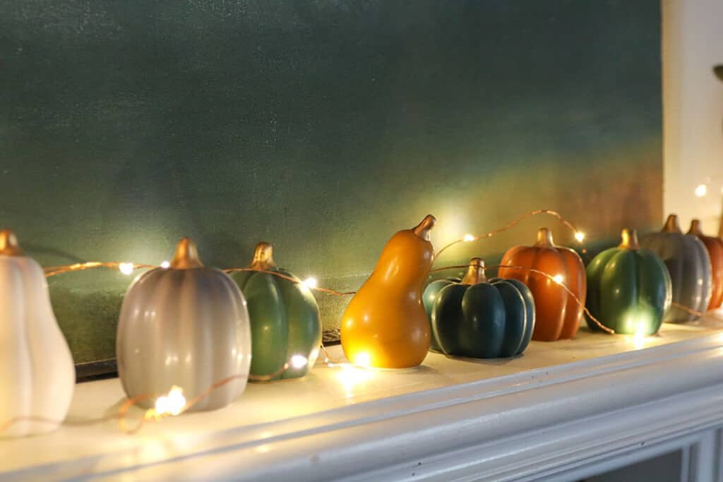 Fall decorating tips for your fireplace mantel using colorful faux pumpkins and fairy lights
