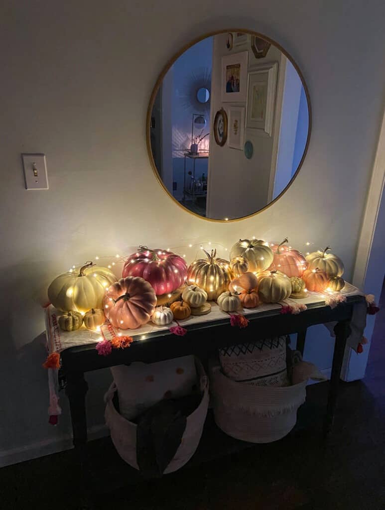 Fall entryway with lots of colorful pumpkins and fairy lightsFall decorating tips for inside your home — 4 easy decor ideas that make your home feel extra festive and cozy with all the hygge vibes!