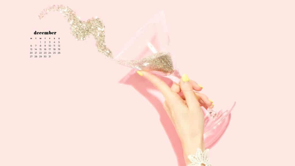 hand holding martini of gold glitter spilling out on light pink background