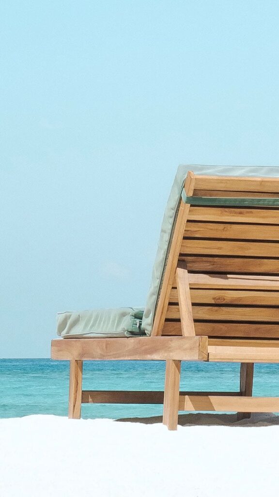 2 wooden beach chairs looking a a beautiful beach