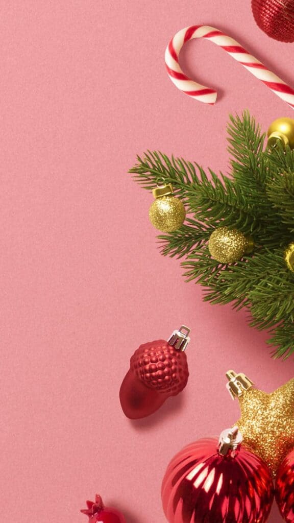 red ornaments, greenery, candy canes on pink background - free december digital wallpapers