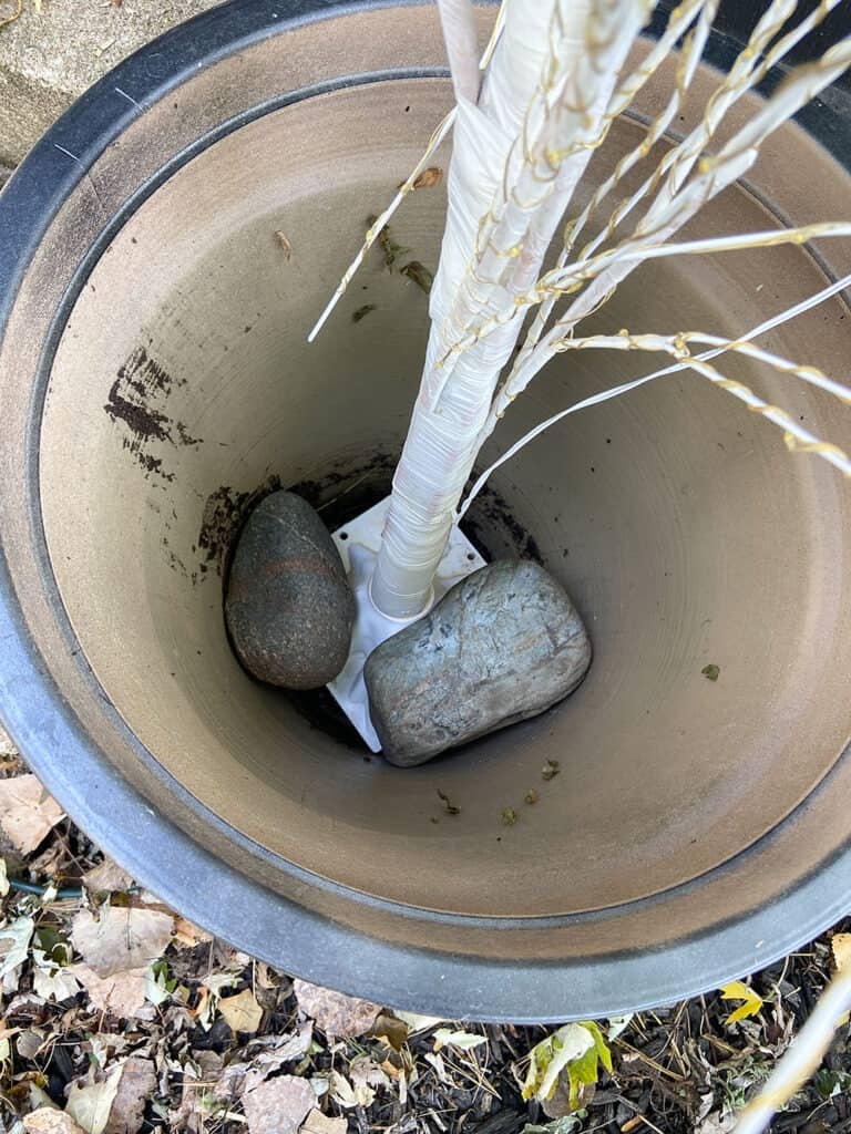 light up white birch trees in larger flower pots for front porch decor ideas - secure with rocks