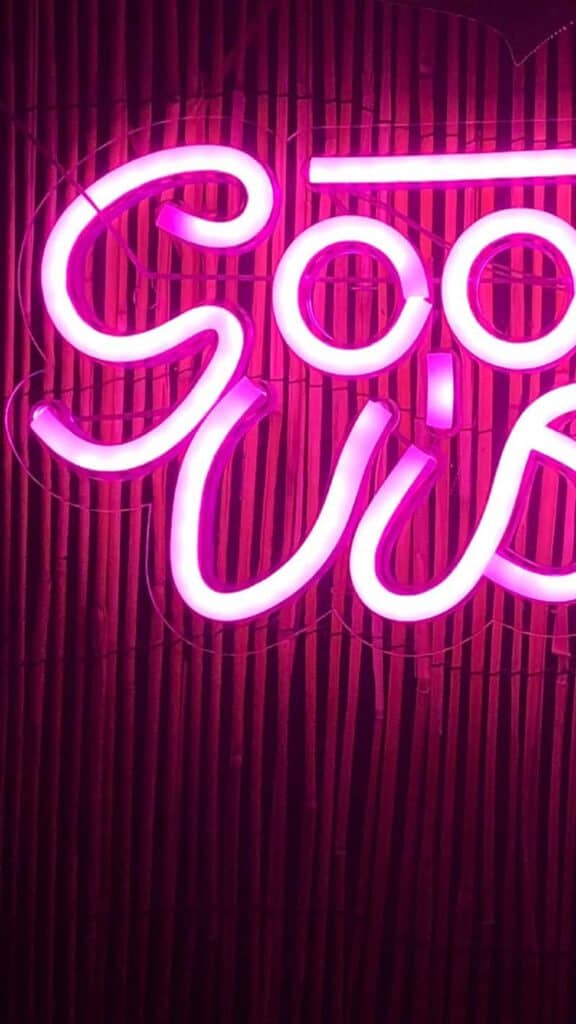 pink good vibes neon sign on bamboo background