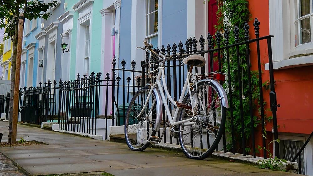 colorful homes in notting hill london with a bike leaning on gate