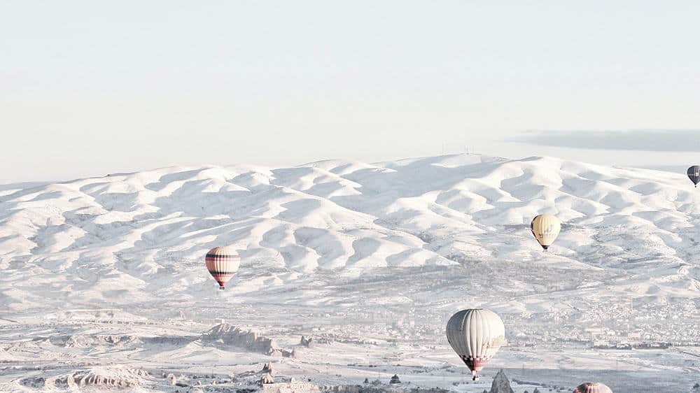 wintery snow covered mountains and hot air balloons