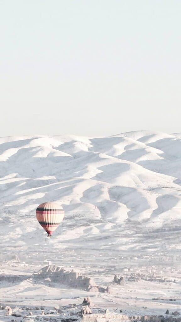 wintery snow covered mountains and hot air balloons