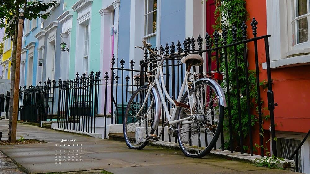 colorful homes in notting hill london with a bike leaning on gate