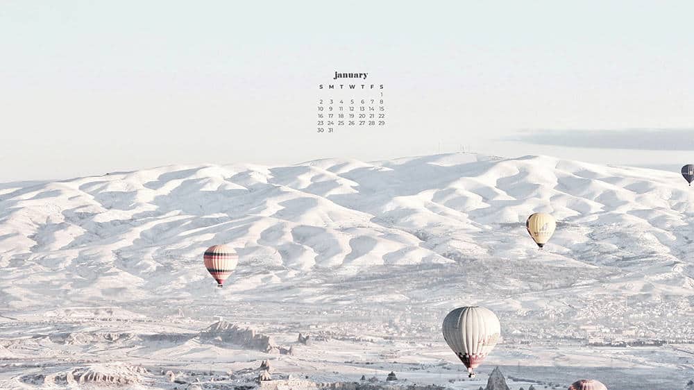 wintery snow covered mountains and hot air balloons