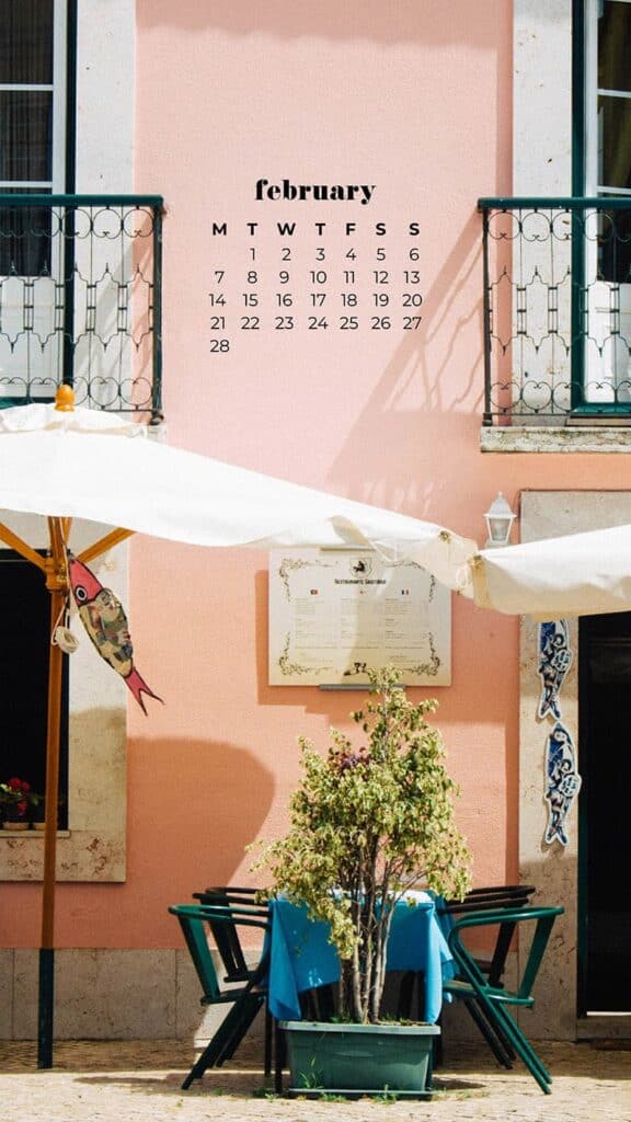 European pink cafe with white umbrella tables outside