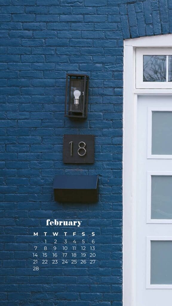 blue painted brick building with white door next to a pink painted brick building with white door london flat