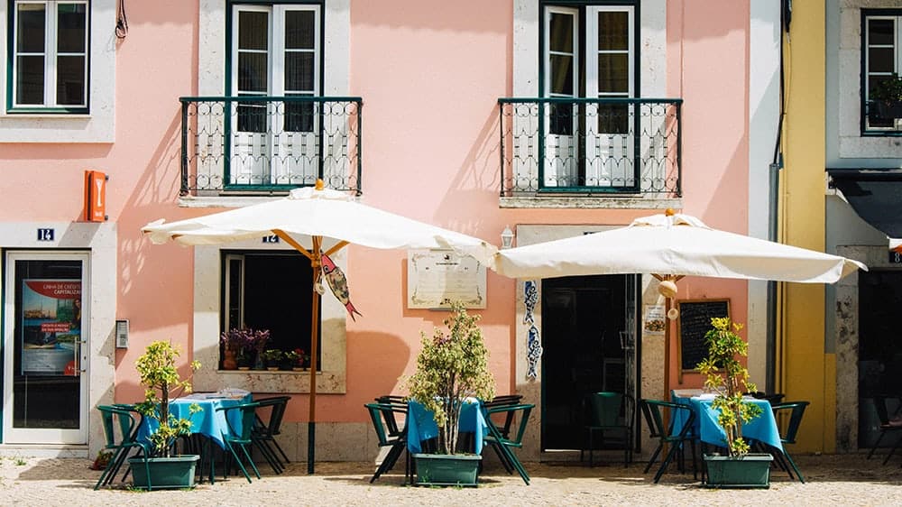 European pink cafe with white umbrella tables outside