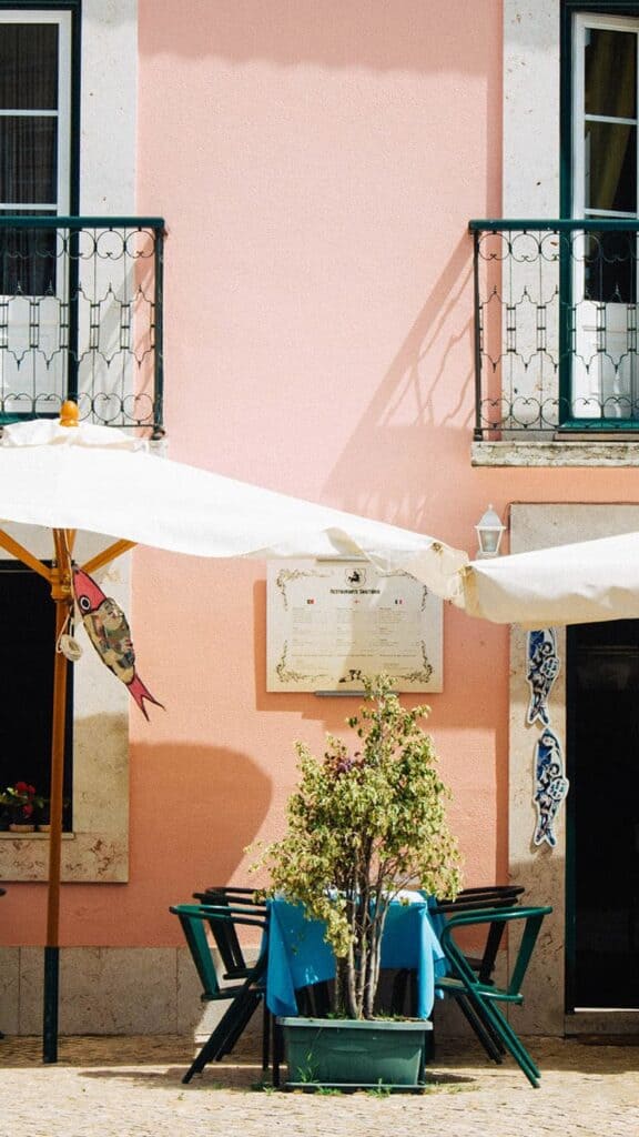 European pink cafe with white umbrella tables outside