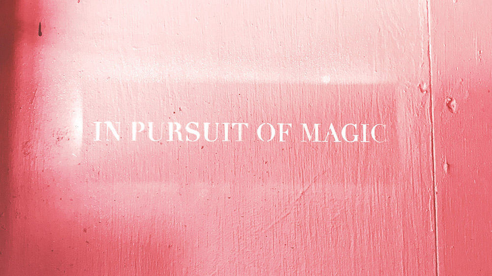 in pursuit of magic spray painted on pink wall