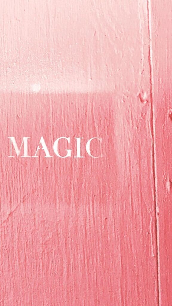 in pursuit of magic spray painted on pink wall